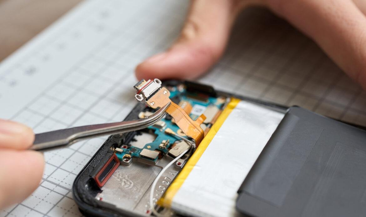 Hands performing disassembly maintenance of smartphones